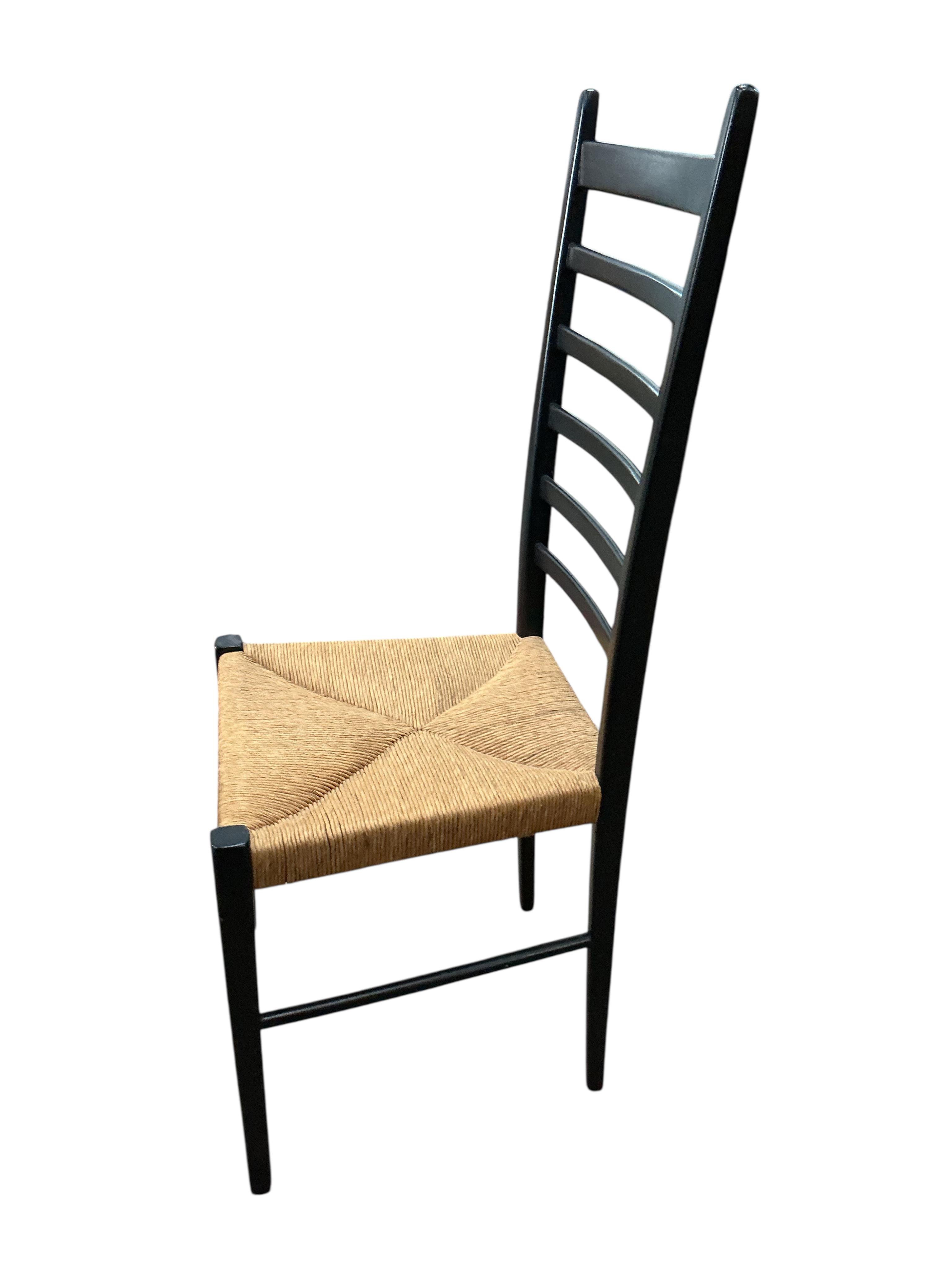 A set of four Gio Ponti ebonised ladderback rush seat dining chairs, width 40cm, depth 41cm, height 107cm